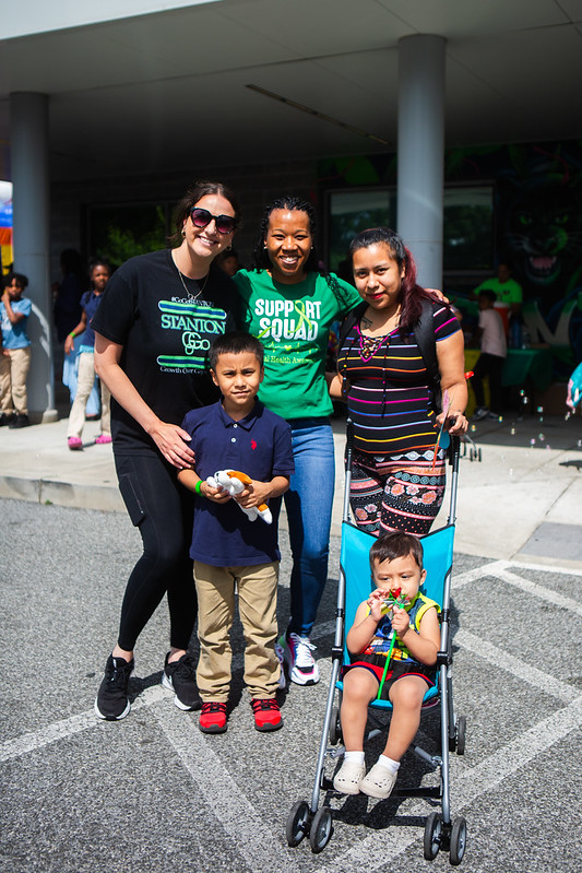 Three women posing with two children outdoors